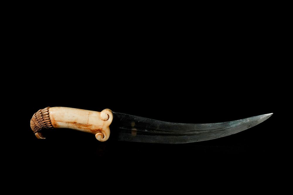 Lot 278: A Mughal Bone-Handled Dagger with Carved Eagle-Head Pommel.