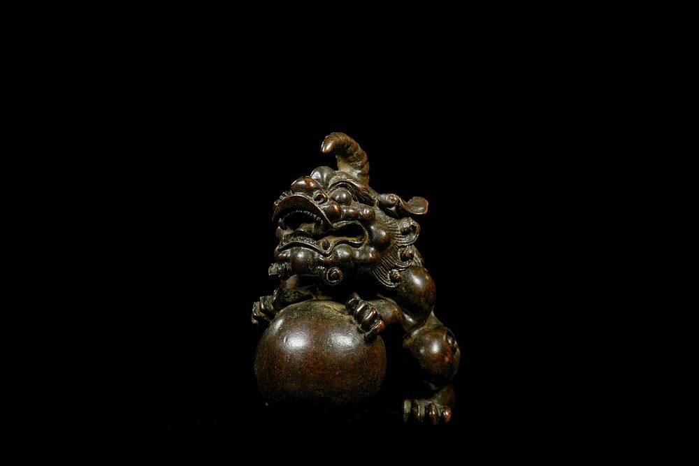 Lot 343: A Chinese Bronze Foo Lion Figure Grasping a...