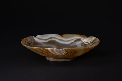 A Roman Agate Carved Bowl, 1st–3rd Century AD. A carved agate bowl displaying warm banded tones 