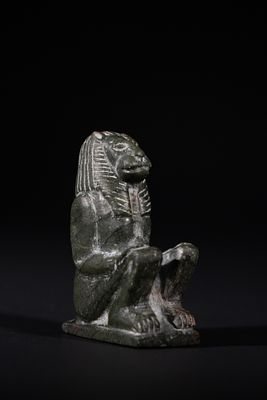 An Egyptian Green Granite Figure of a Seated Lion-Headed Deity, New Kingdom, Possibly Circa 