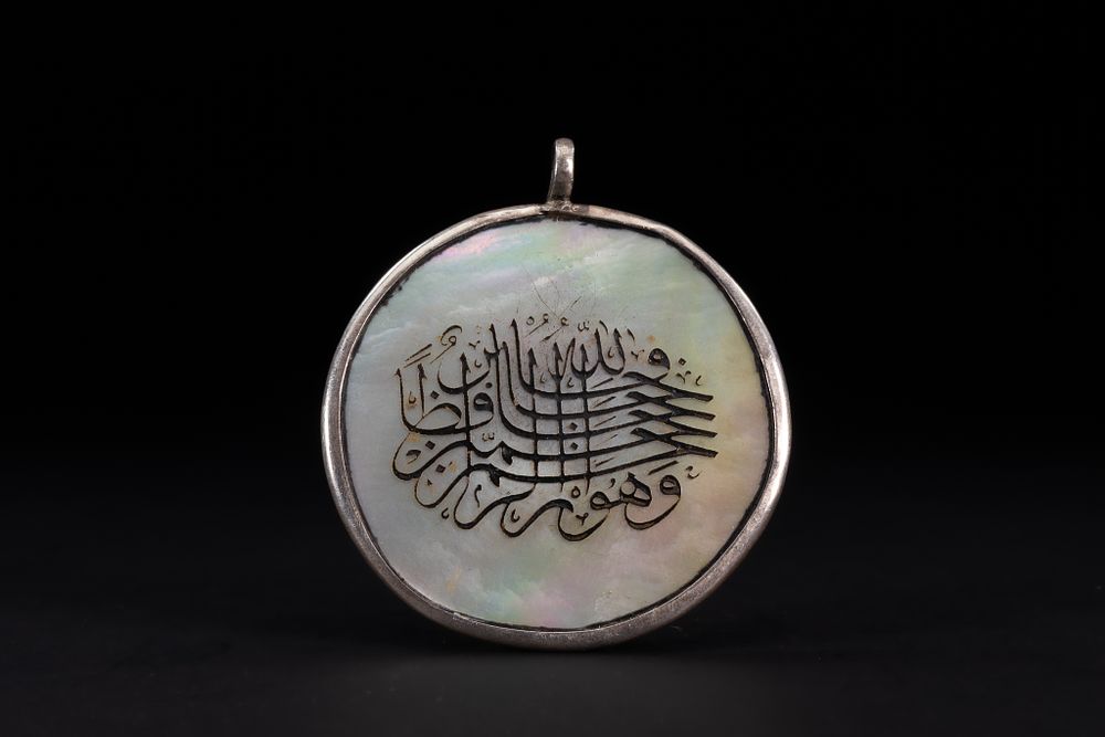 Lot 178: An Islamic Mother-of-Pearl Amulet Pendant with Calligraphic Inscription.