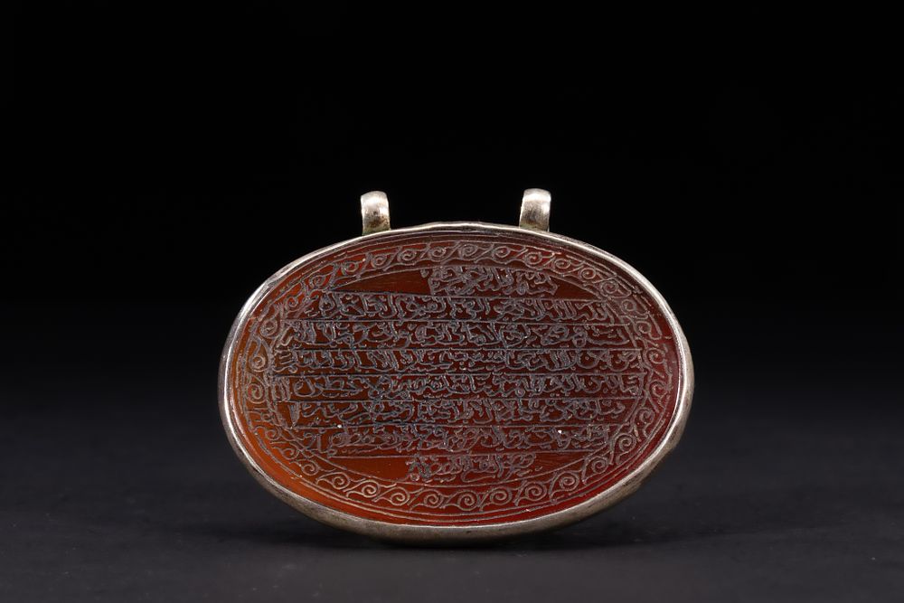 Lot 179: An Islamic Oval Carnelian Amulet Pendant Engraved with...
