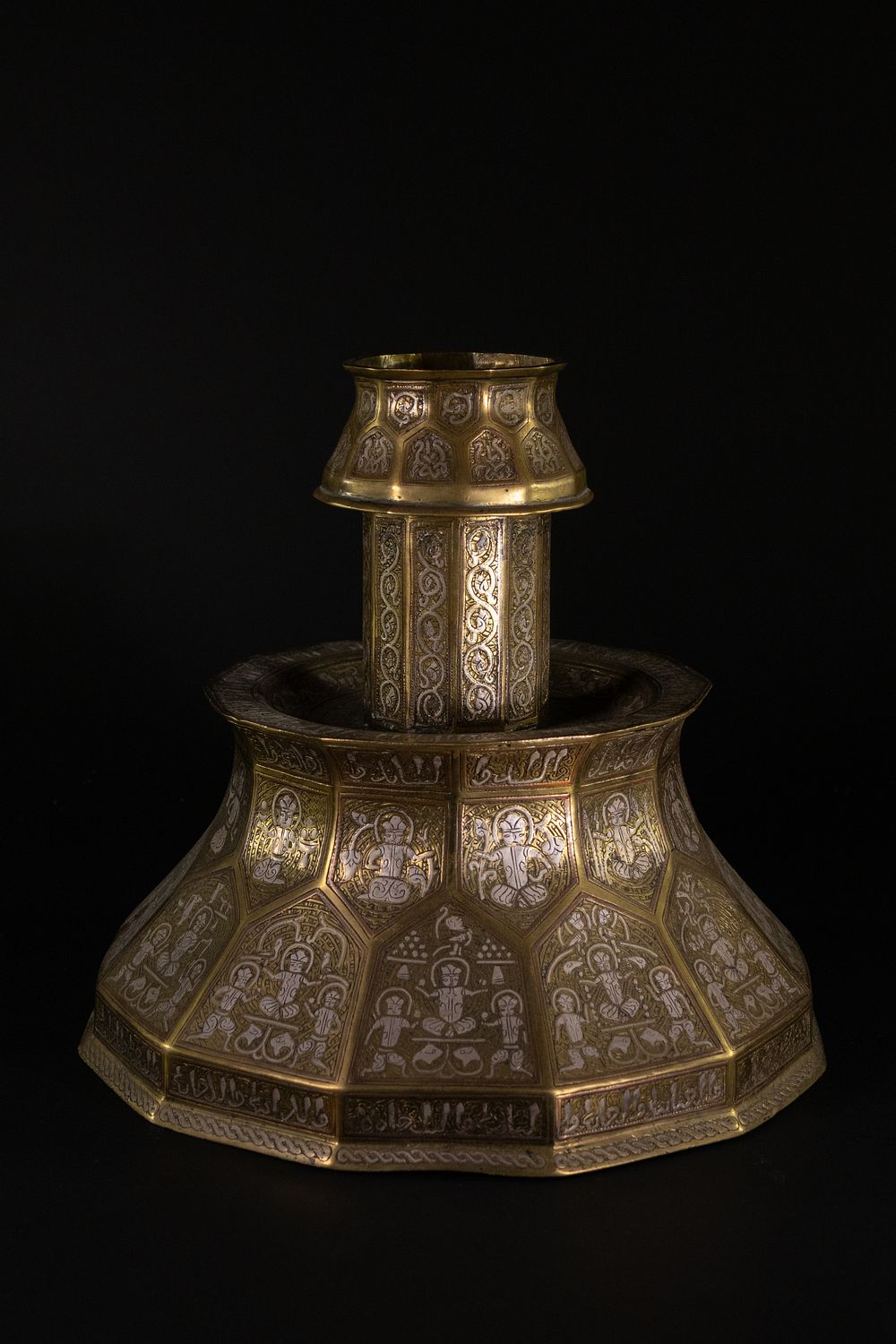 Lot 204: A Khorassan Style Brass and Silver-Inlaid Candlestick.