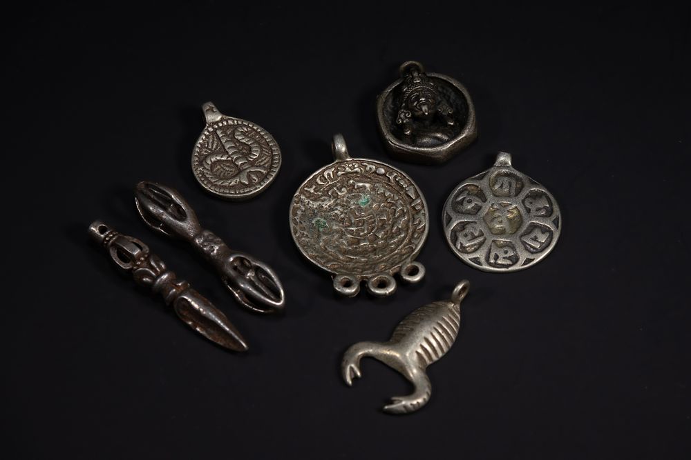 Lot 259: A Collection of Tibetan White Metal Pendants and...