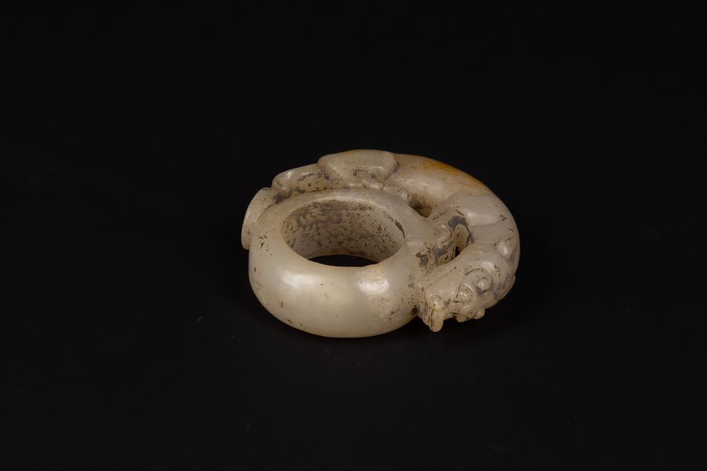 Lot 394: A Chinese Carved Jade Ring with Mythical Beast...