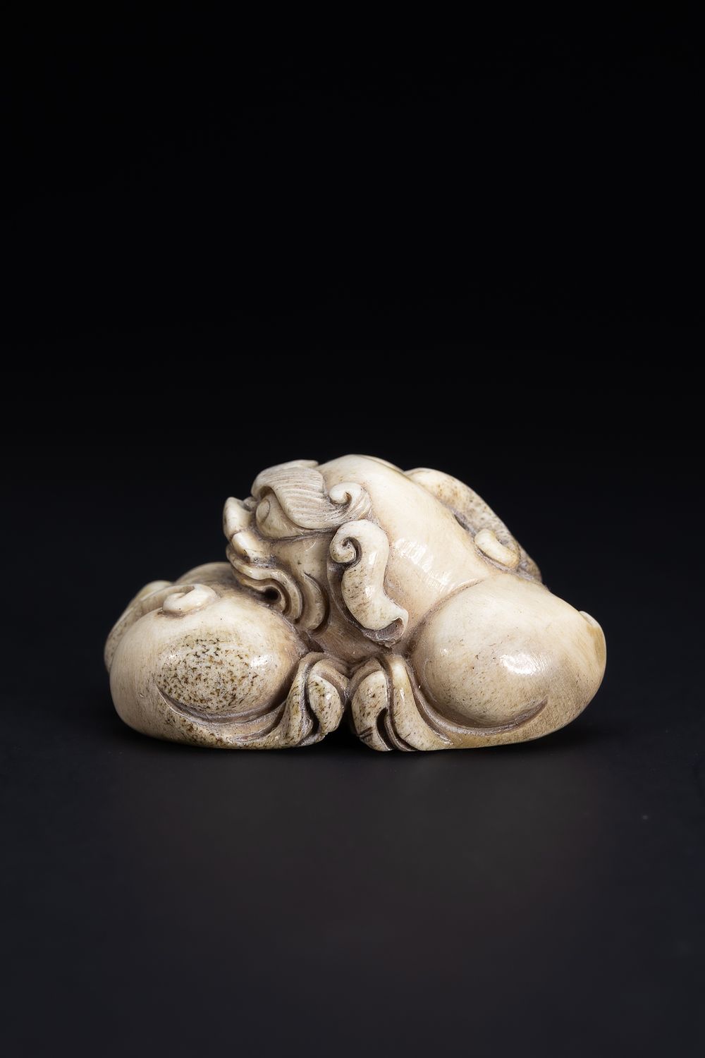 Lot 415: A Chinese Carved Horn Recumbent Mythical Beast.
