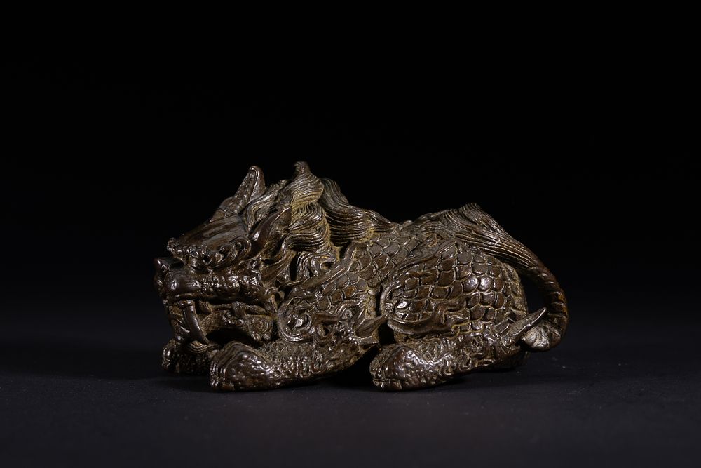Lot 421: A Chinese Bronze Recumbent Qilin Figure.