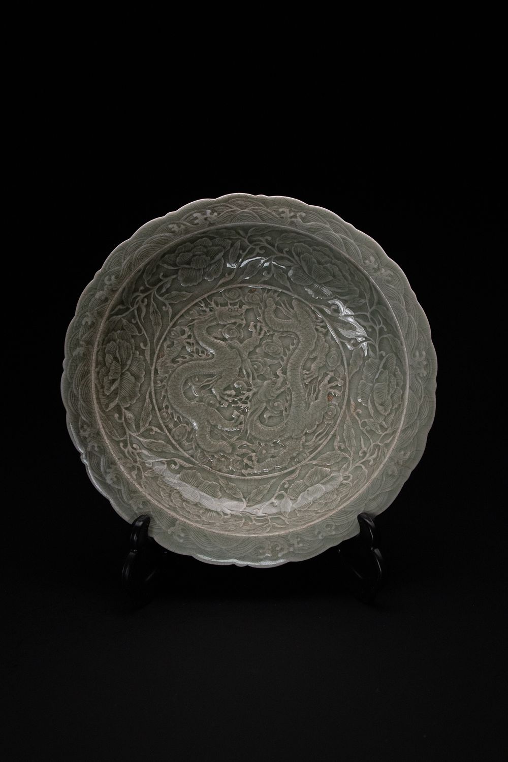 Lot 448: A Chinese Celadon-Glazed Carved ‘Dragon and Peony’ Dish.