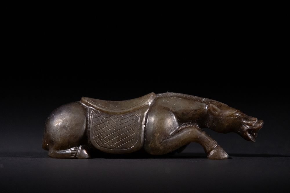 Lot 458: A Chinese Jade Carving of a Recumbent Horse.