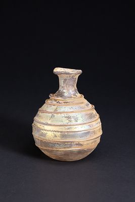 A Roman Ribbed Glass Unguentarium, Circa 1st–3rd Century AD. Free-blown glass vessel of 