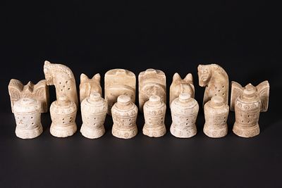 A Complete Stone Half Chess Set, 19th Century. A complete carved stone half chess set 