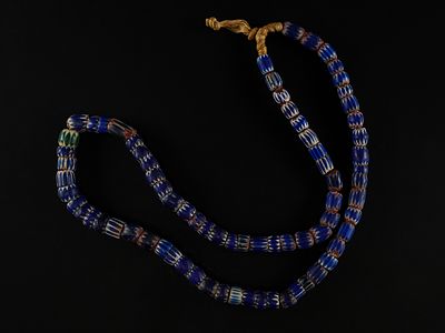 A Strand of African Blue Chevron Trade Beads. A striking strand of African trade beads composed 