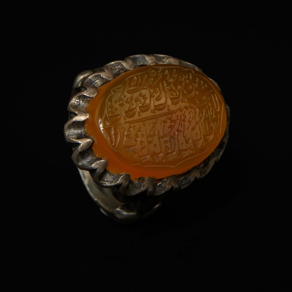 Lot 204: An Islamic Silver Ring Set with a Carved...