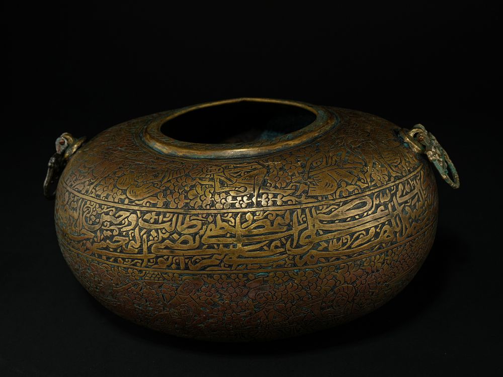 Lot 218: A Qajar Brass Kashkul with Figural and Calligraphic...