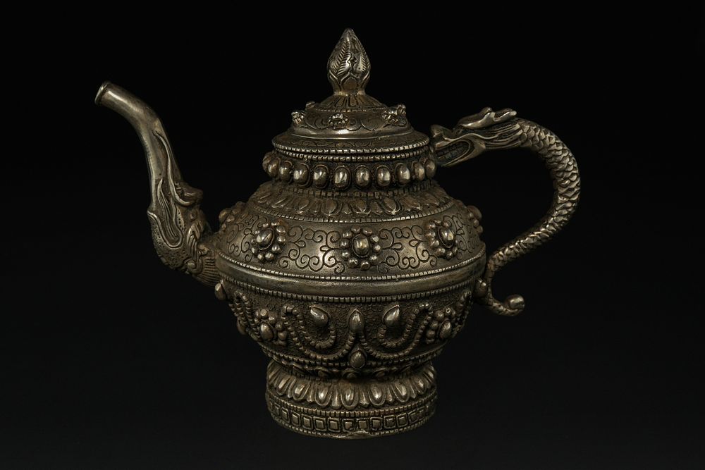 Lot 275: A Tibetan White Metal Teapot with Dragon-Form Handle...