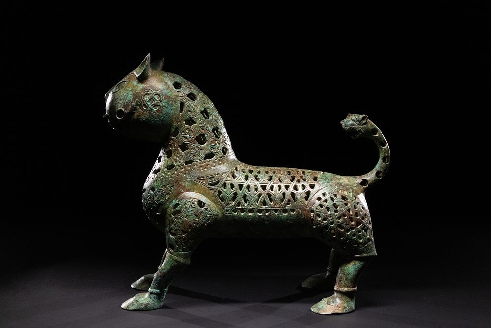 Lot 28: A KHORASAN-STYLE OPENWORK BRONZE LION.