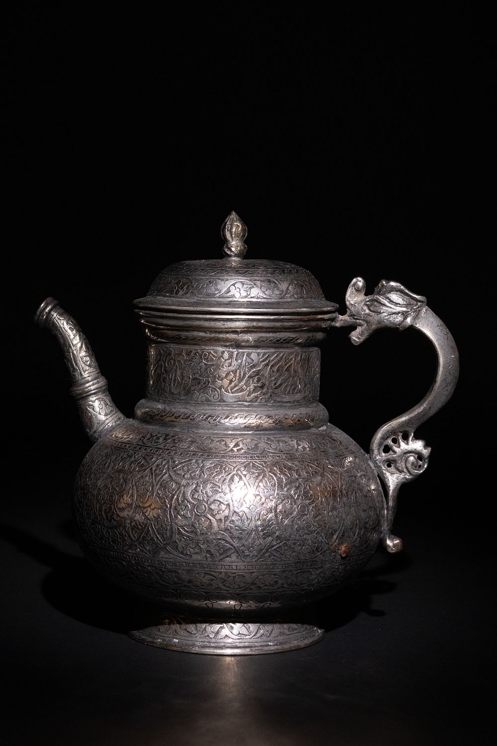 Lot 30: A TIMURID COPPER EWER WITH ENGRAVED CALLIGRAPHY AND DRAGON HANDLE.