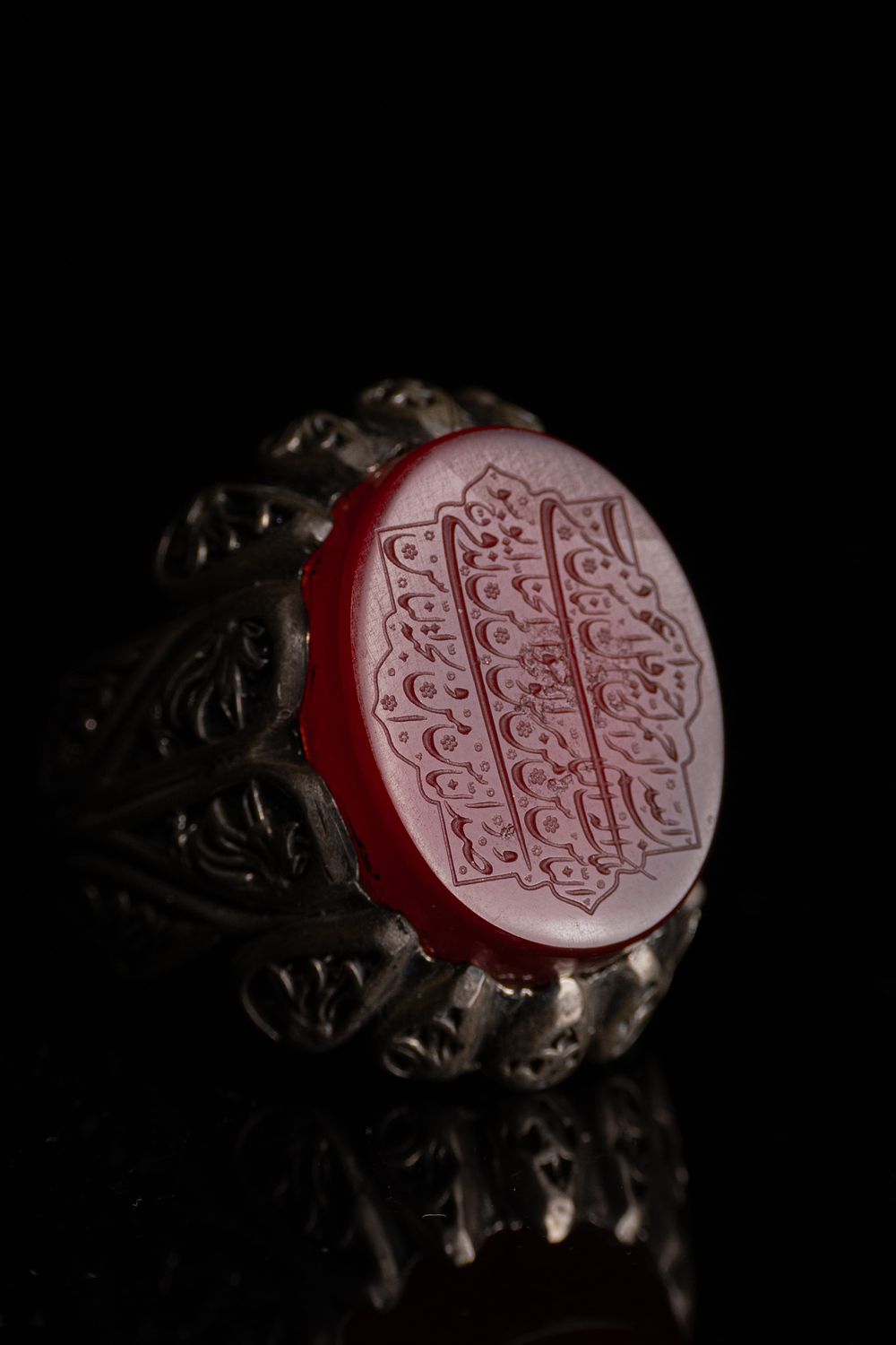 Lot 36: AN ISLAMIC SILVER SIGNET RING SET WITH AN ENGRAVED RED AGATE INTAGLIO