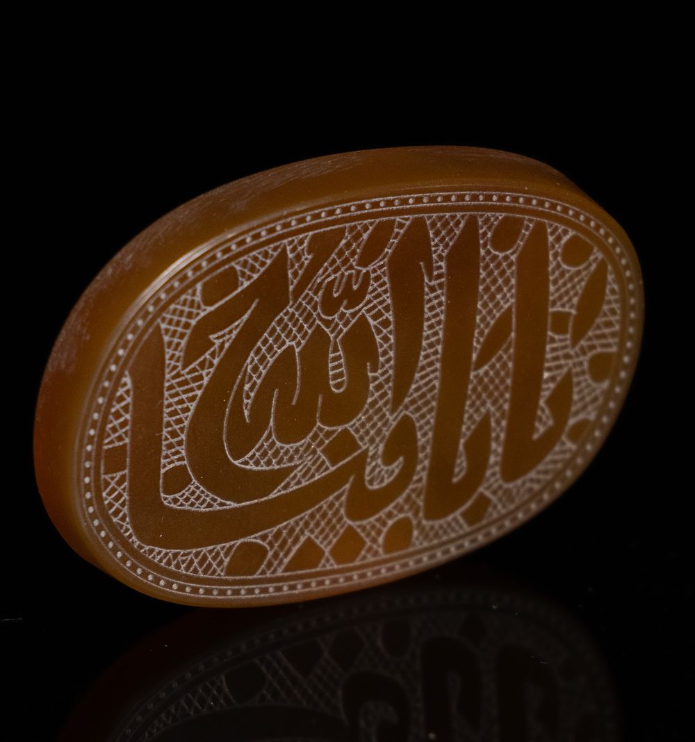 Lot 42: A LARGE ISLAMIC CARVED HONEY CARNELIAN CALLIGRAPHIC AMULET PLAQUE.