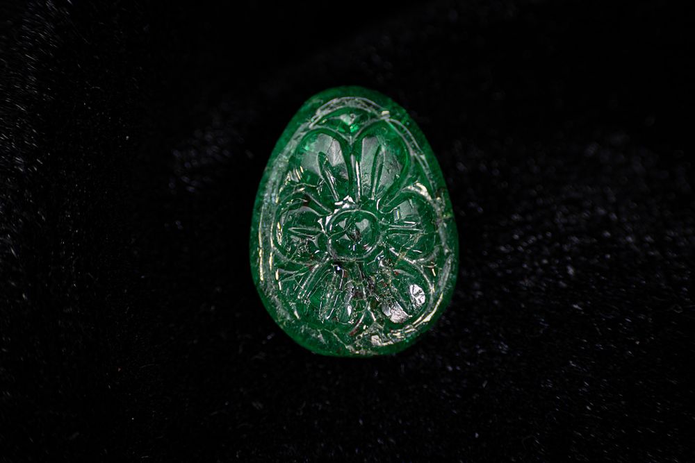 Lot 49: A MUGHAL STYLE EMERALD INTAGLIO WITH FLORAL ROSETTE.