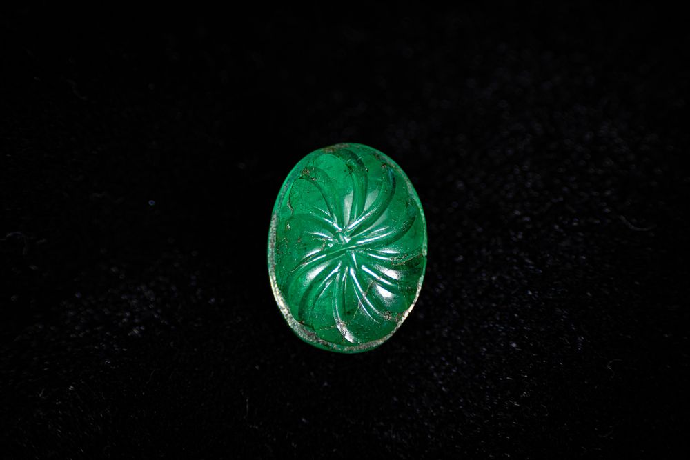 Lot 50: A MUGHAL STYLE EMERALD INTAGLIO WITH FLORAL MOTIF.