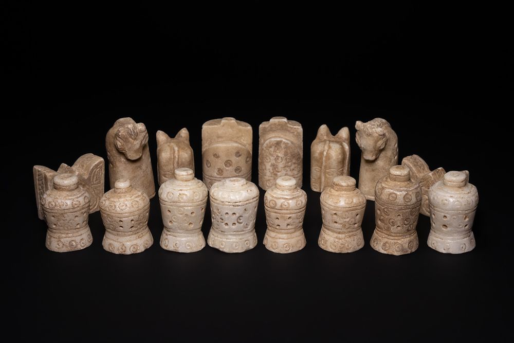 Lot 57: A COMPLETE ISLAMIC CARVED STONE HALF CHESS SET, 19TH CENTURY.