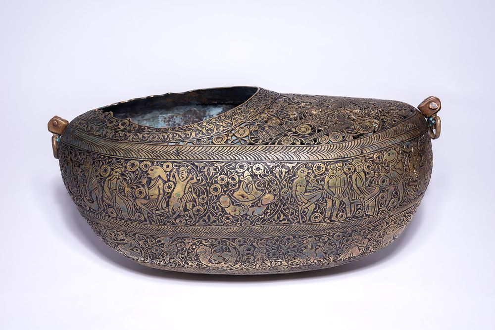 Lot 70: A QAJAR BRASS KASHKUL BEGGARS BOWL WITH OPENWORK DECORATION.