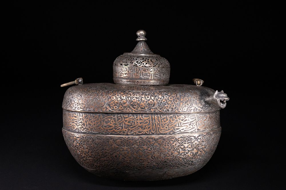 Lot 77: A RARE SAFAVID TINNED COPPER LIDDED KASHKUL BEGGAR'S BOWL WITH ARABIC INSCRIPTIONS, 17TH CENTURY.