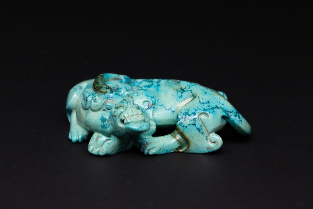Lot 85: A CHINESE CARVED TURQUOISE RECUMBENT MYTHICAL BEAST.