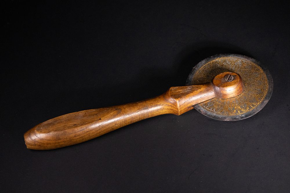 Lot 111: AN OTTOMAN STEEL AND WOOD PASTRY WHEEL WITH GOLD KOFTGARI WORK, 18TH–19TH CENTURY.