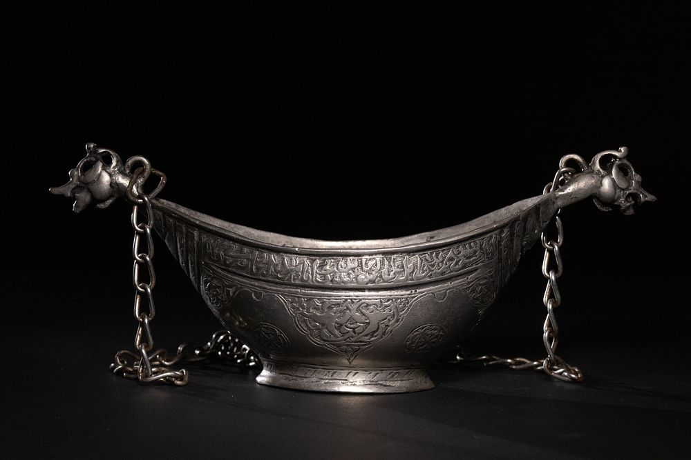 Lot 125: A SAFAVID TINNED-COPPER KASHKUL (BEGGAR’S BOWL) WITH DRAGON-HEAD TERMINALS.