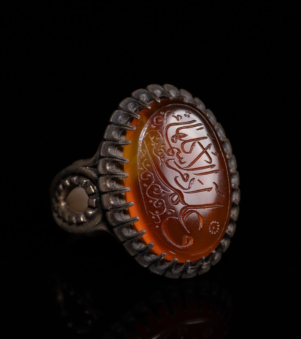 Lot 131: AN ISLAMIC INSCRIBED SILVER AND CARNELIAN AGATE SIGNET RING.