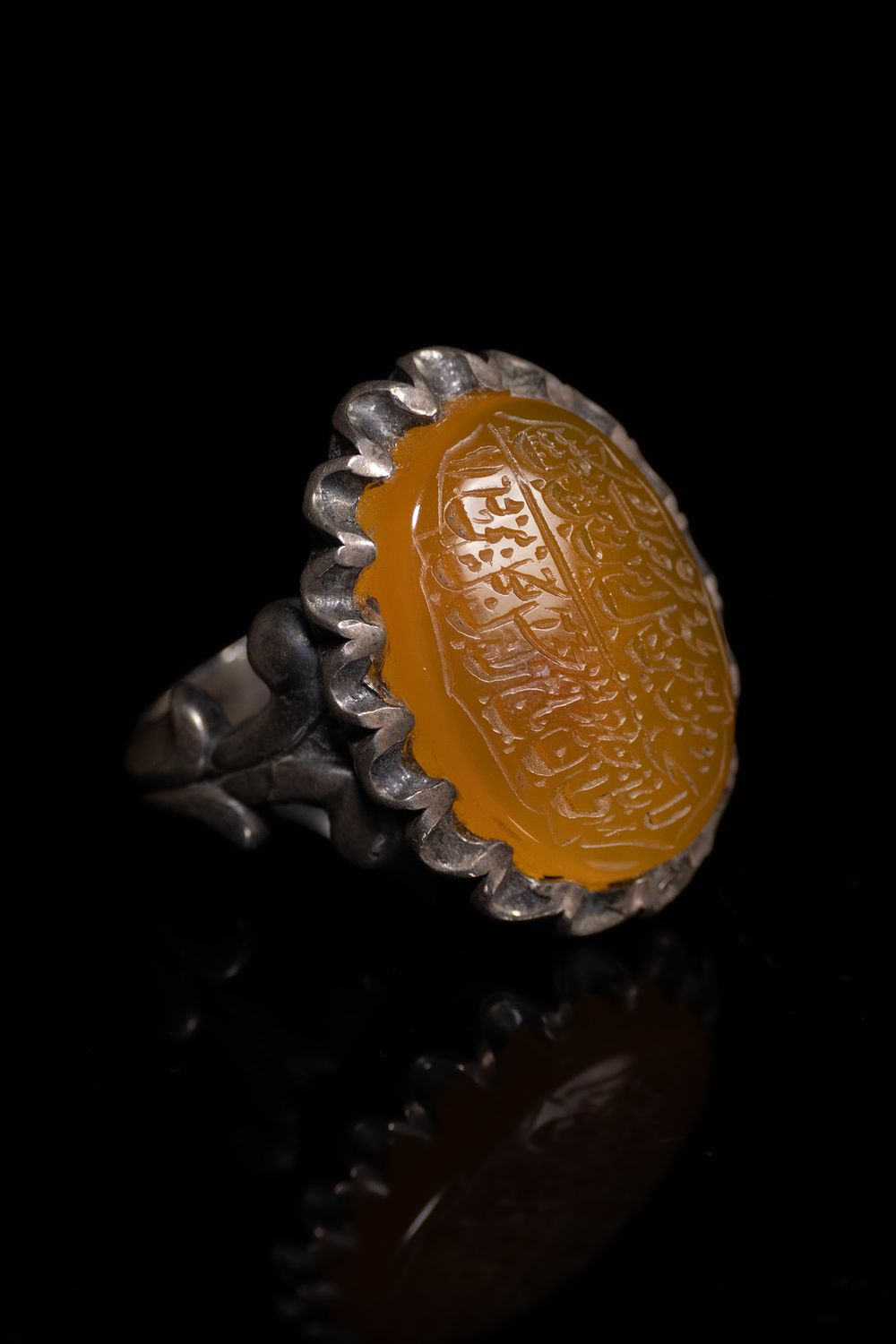 Lot 133: AN ISLAMIC SILVER AND ENGRAVED YELLOW AGATE SIGNET RING