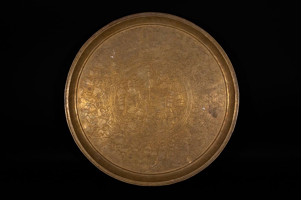 Lot 142: A QAJAR BRASS TRAY WITH COURTLY SCENE, PERSIA, 19TH–20TH CENTURY.