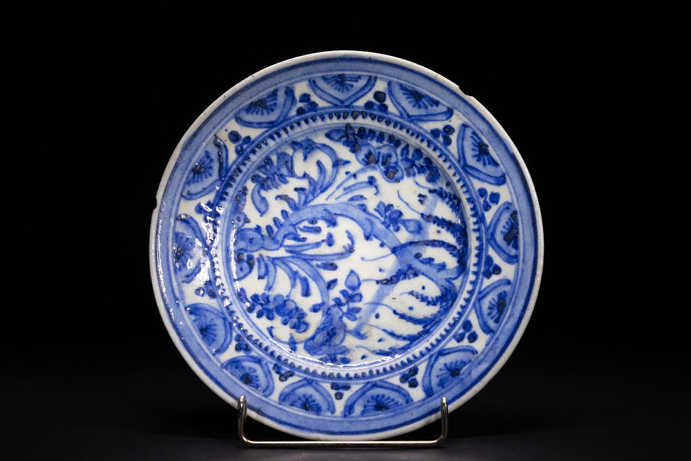Lot 165: A SAFAVID BLUE AND WHITE POTTERY DISH WITH FLORAL ARABESQUES, 17TH CENTURY.