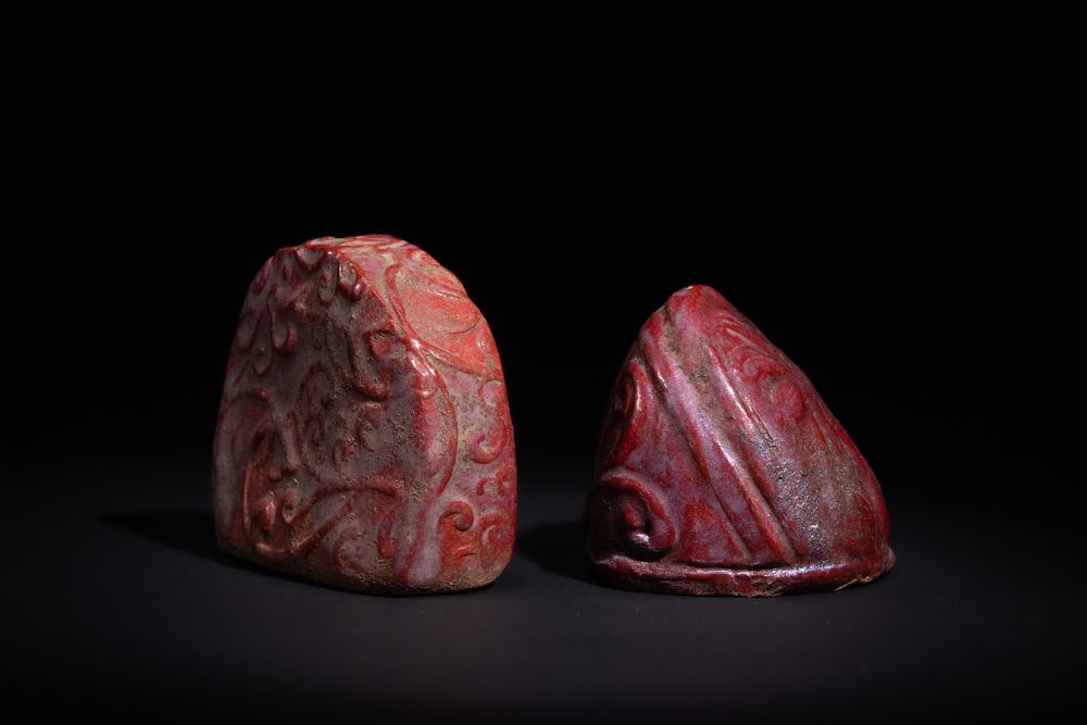 Lot 169: A PAIR OF ISLAMIC CARVED RED STONE CHESS PIECES, 19TH CENTURY.