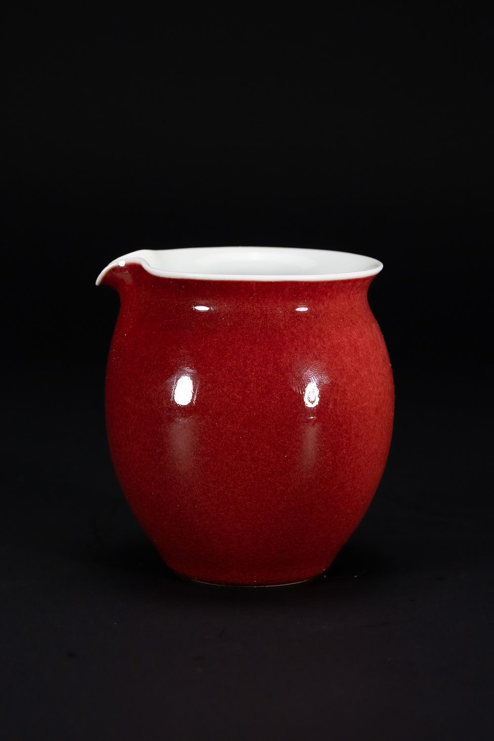 Lot 194: A CHINESE MONOCHROME COPPER-RED GLAZED PORCELAIN POURING VESSEL, YONGZHENG MARK.