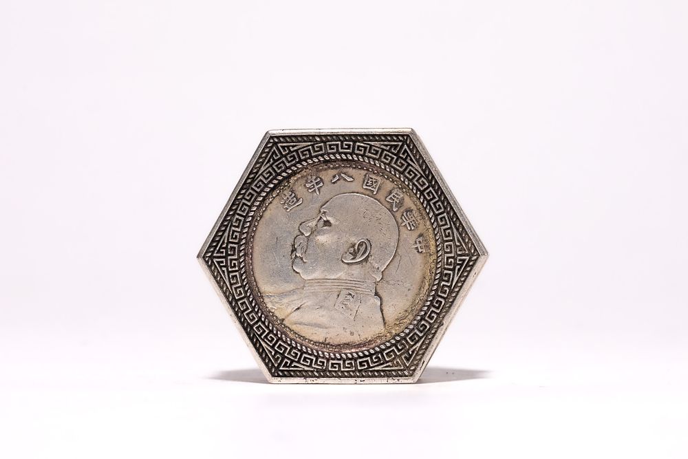 Lot 206: A CHINESE HEXAGONAL SILVER-COLOURED BOX WITH REPUBLIC OF CHINA YEAR 8 COIN DESIGN.
