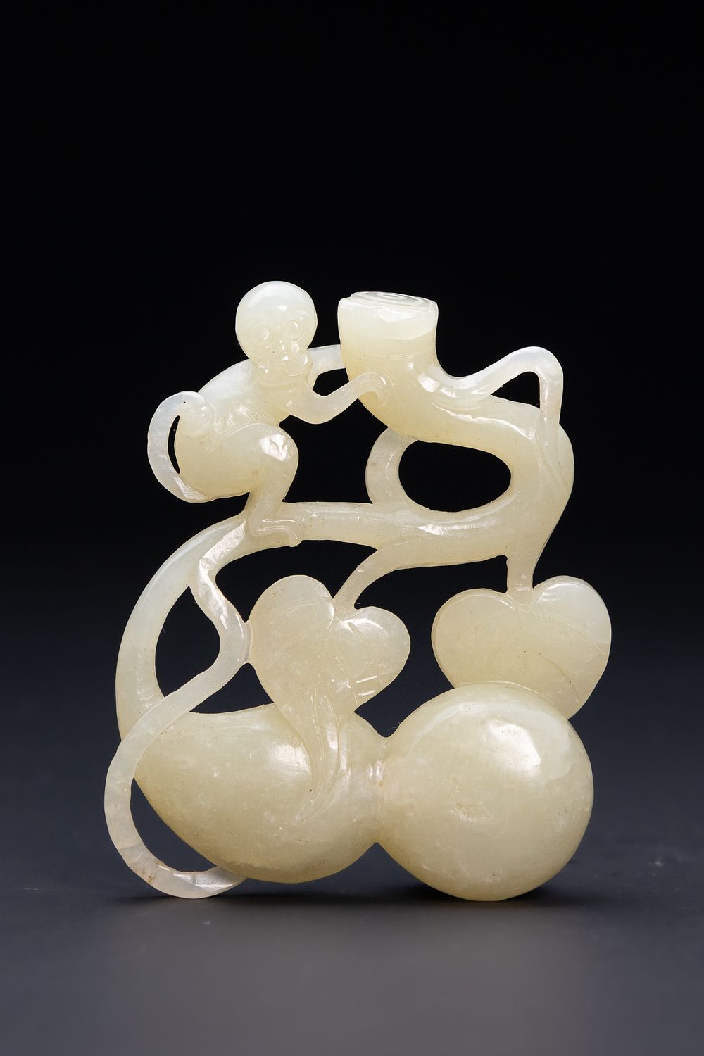 Lot 219: A CHINESE CARVED WHITE JADE MONKEY AND DOUBLE GOURD GROUP