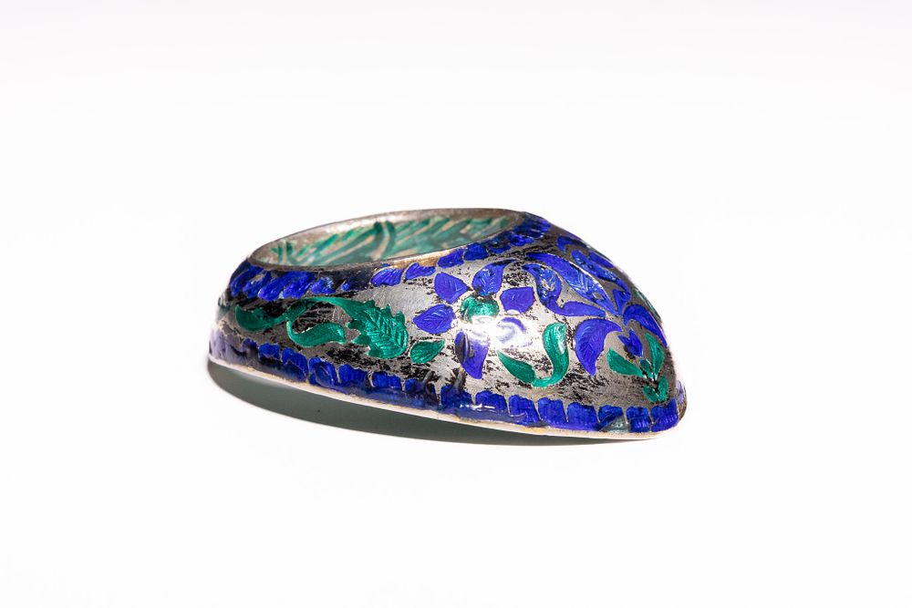 Lot 229: AN INDIAN SILVER AND ENAMEL ARCHER'S RING, 19TH CENTURY.