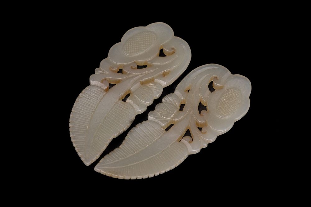 Lot 233: A PAIR OF CHINESE CARVED WHITE JADE LEAF AND SHOU CHARACTER ORNAMENTS.