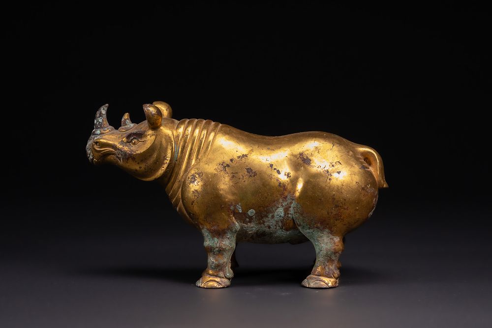 Lot 239: A CHINESE GOLD GILT-BRONZE FIGURE OF A RHINOCEROS.