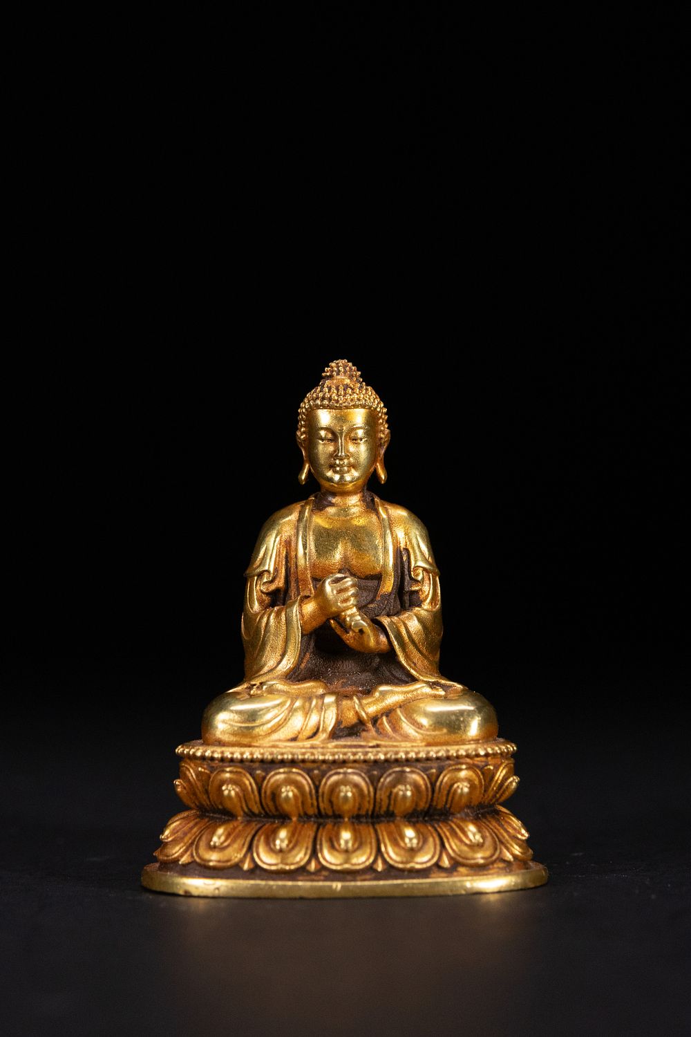 Lot 252: A TIBETAN GILT BRONZE FIGURE OF SHAKYAMUNI.