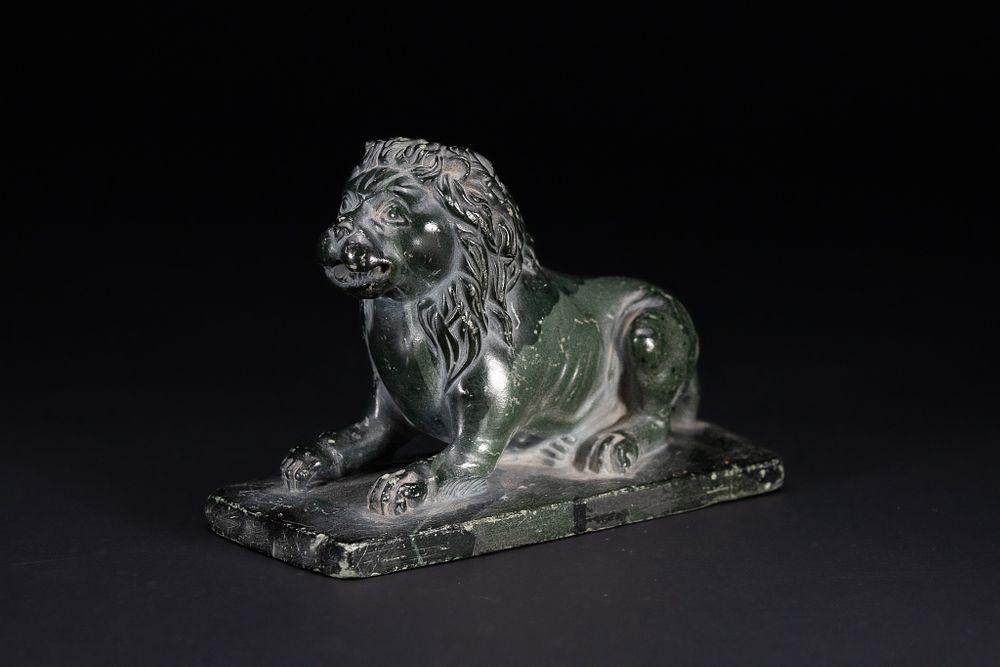 Lot 317: A CHINESE CARVED STONE RECUMBENT LION.