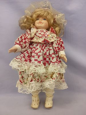 Porcelain and Cloth Doll. The doll features a delicate porcelain head, hands, and feet, paired 