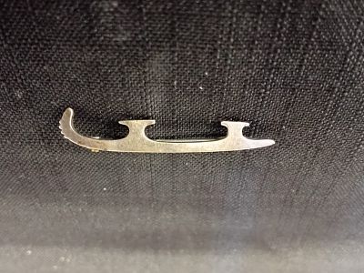 Silver Figure Skate Broach . A small, decorative pin designed in the shape of a figure skate
