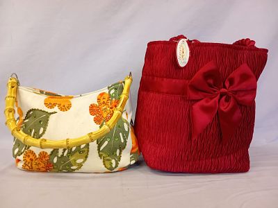 Two Ladies Handbags. A charming white handbag adorned with vibrant orange flowers and green 