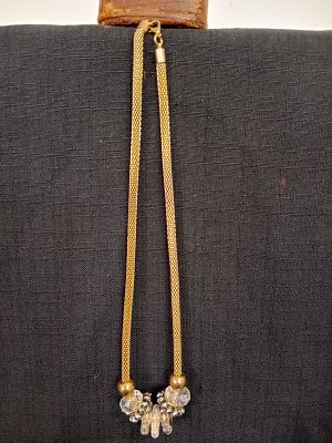 Gold-tone Accessory Necklace . This necklace features a flexible hollow tube design crafted from 