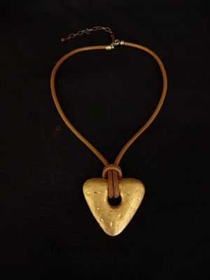 Golden Heart Necklace. A metal heart pendant with a gold-tone finish. The heart has a central 