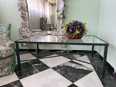 A green-painted iron coffee table with glass top 49 x 80 x 131 cm 150 - 200 €